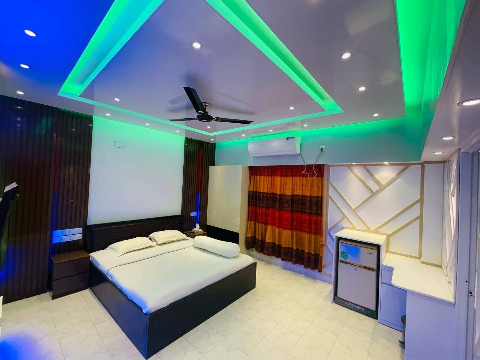 Room with green cove lighting and TV